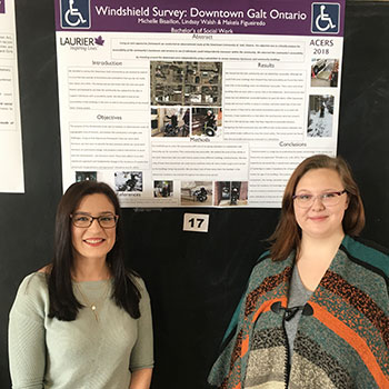 two female students in front of poster