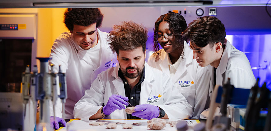 Rouleau in the lab with students researching the brain