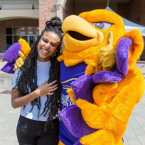 Woman standing with Midas mascot.