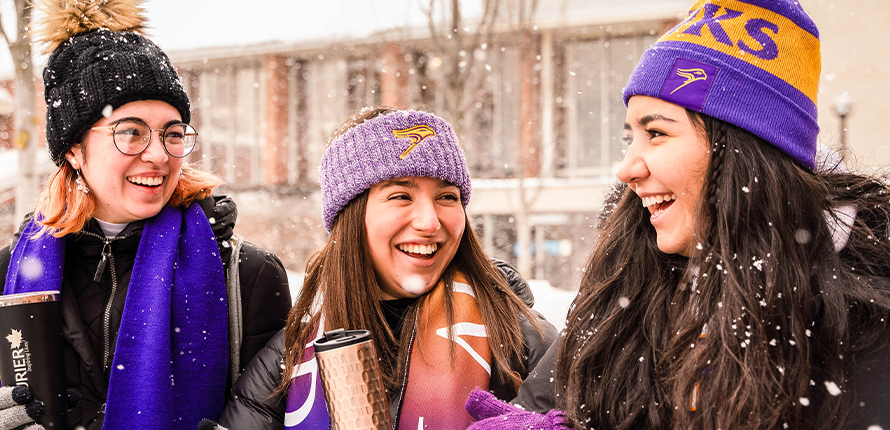 Three Laurier students with their arms around each other smiling at the camera