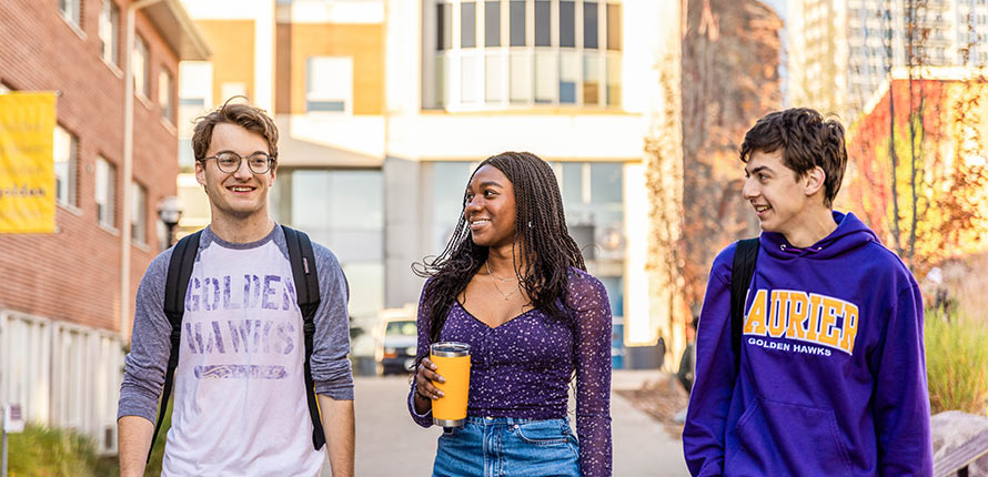 three students on waterloo campus in spring