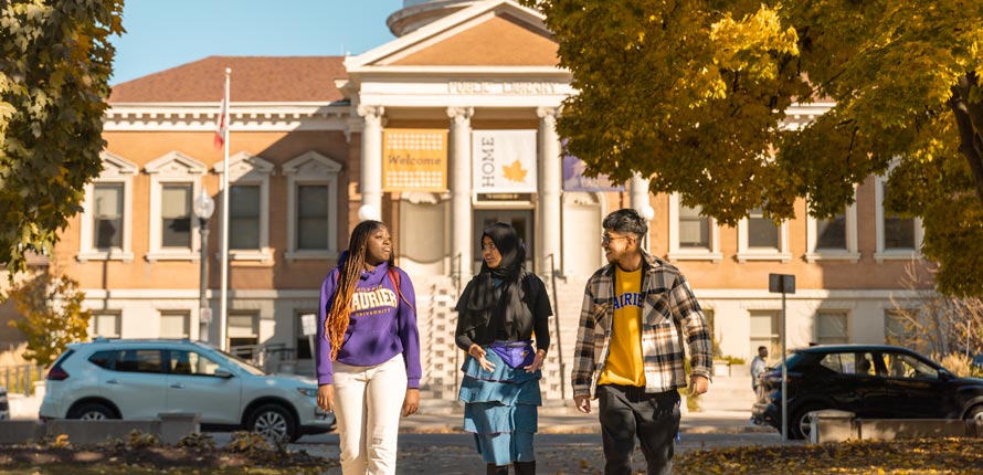 three students walking outside of canergie building