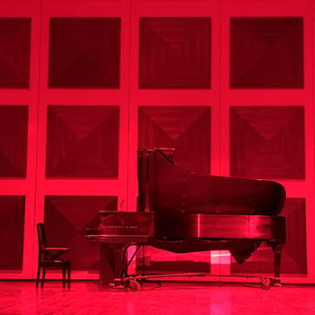 Piano on a stage with red lighting